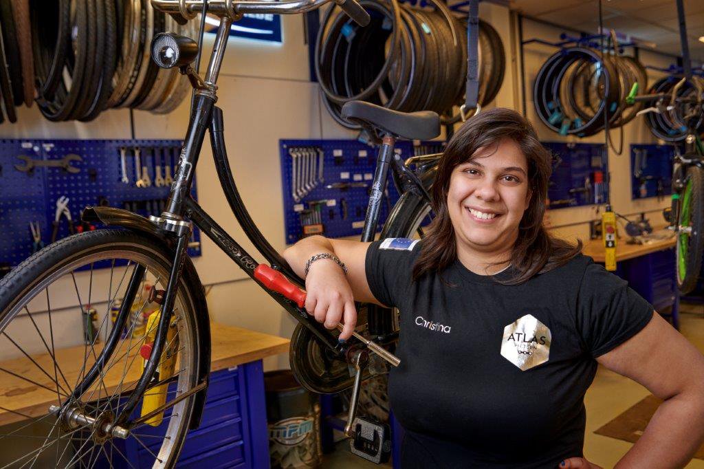 Vrouw in fietsreparatie werkplaats als onderdeel van praktijkonderwijs.