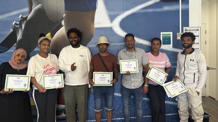 Groep Eritrese nieuwkomers toont trots hun certificaten na het afronden van de MAP-training.