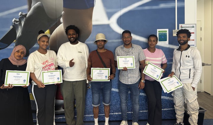 Groep Eritrese nieuwkomers toont trots hun certificaten na het afronden van de MAP-training.